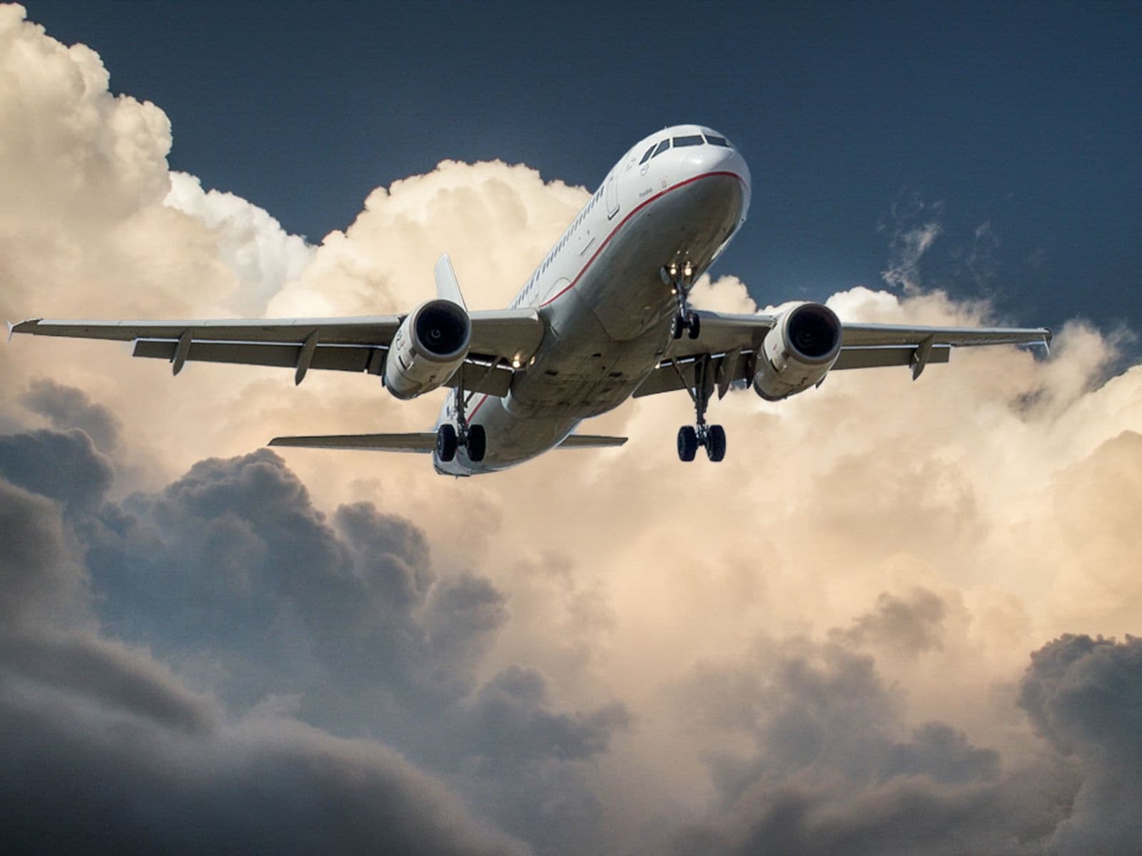 Commercial aircraft in flight above cloud cover